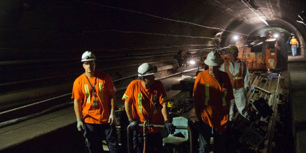 Amtrak crew members work at a repair site in the north tube of the North River Tunnel under the Hudson River near near Weehawken, New Jersey, U.S., on early Friday morning, Aug. 21, 2015. An Amtrak crew worked to repair a 400 foot section of a transmission cable, part of a 15,000 foot cable, that provides power to the catenary system that moves the trains through the tunnel. Photographer: Victor J. Blue/Bloomberg via Getty Images