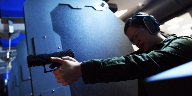 A woman fires a handgun at the RTSP shooting range in Randolph, New Jersey on December 9, 2015. US President Barack Obama cal
