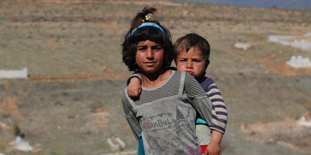 HATAY, TURKEY - FEBRUARY 16: A Syrian refugee girl and a toddler, fled from Assad Regime's assaults with their families, are seen outside of the makeshift tents near a cemetery in Turkey's Syrian Border city Hatay's Kirikhan District on February 16, 2016. Approximately 125 Syrians, including 35 children, fled from civi war and lives in harsh conditions in their tents. (Photo by Burak Milli/Anadolu Agency/Getty Images)