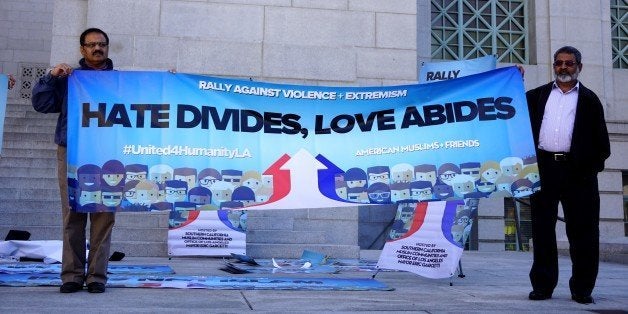 LOS ANGELES, UNITED STATES - DECEMBER 13: Protesters hold a banner written 'Hate divides, love abides' on it as hundreds of Californians, mostly including Muslims, gathered during a protest against terrorism and violence, staged with the attendance of Los Angeles Mayor Eric Garcetti (not seen), San Bernardino Mayor Carey Davis (not seen) and Chief of the Los Angeles Police Department Charlie Beck (not seen) with some prominent Muslims of the society, in front of the Los Angeles City Hall on December 13, 2015 in Los Angeles, CA, USA. (Photo by Mintaha Neslihan Eroglu/Anadolu Agency/Getty Images)