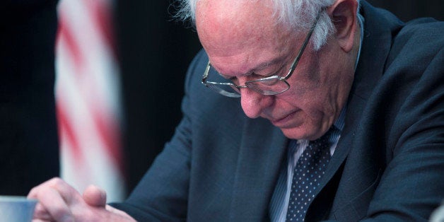Democratic presidential candidate, Sen. Bernie Sanders, I-Vt. bows his head during a prayer at a breakfast with faith leaders