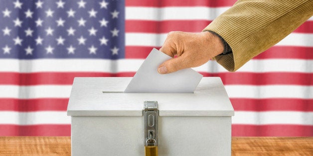 Man putting a ballot into a voting box - USA