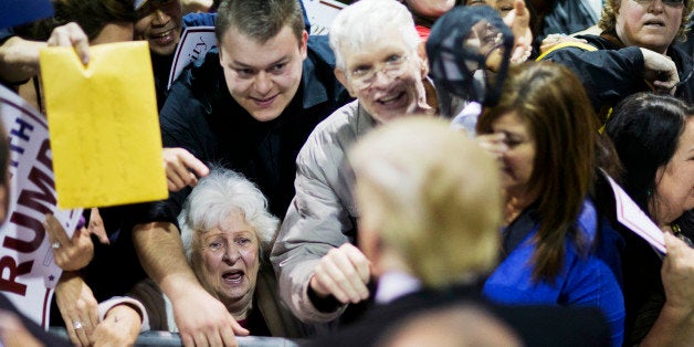 An audience member talks to Republican presidential candidate Donald Trump, left, as he signs autographs at a campaign event Sunday, Feb. 21, 2016, in Atlanta. (AP Photo/David Goldman)