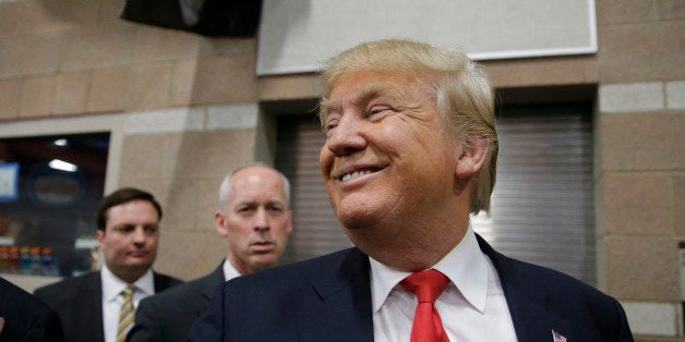 Republican presidential candidate Donald Trump smiles as he greets voters at a caucus site Tuesday, Feb. 23, 2016, in Las Veg