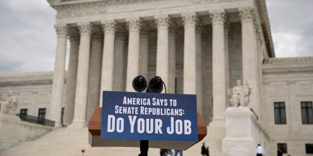 A message sign is attached to a lectern awaiting a news conference by Senate Democrats who are urging Senate Republicans to relent on their decision to take no action on anyone President Barack Obama nominates to fill the Supreme Court vacancy created by the death of Justice Antonin Scalia, at the Supreme Court on Capitol Hill in Washington, Thursday, Feb. 25, 2016. (AP Photo/J. Scott Applewhite)