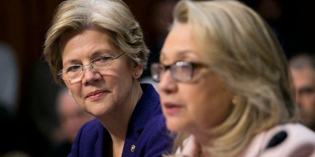 Senator Elizabeth Warren, a Democrat from Massachusetts, left, looks on as U.S. Secretary of State Hillary Clinton speaks dur