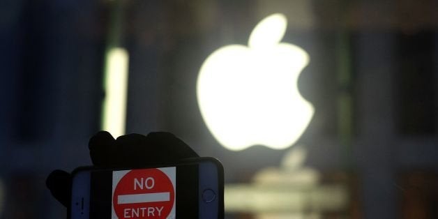 An anti-government protester holds up his iPhone with a sign 'No Entry' during a demonstration near the Apple store on Fifth