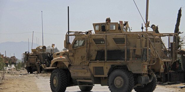 U.S. military vehicles stage at the site of a suicide attack that targeted a convoy of American troops in Jalalabad, east of Kabul, Aghanistan, Friday, April 10, 2015. An Afghan official says the bomb killed and wounded several civilians. The Taliban have claimed responsibility for the attack. (AP Photo)