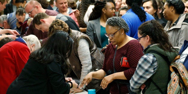 Voters crowd in to check with precinct captains at a Democratic caucus late Tuesday, March 1, 2016, in Denver. Colorado is one of 12 states casting votes for party nominees on Super Tuesday, which offers candidates the chance to garner the biggest single-day delegate haul of the nomination contests. (AP Photo/David Zalubowski)