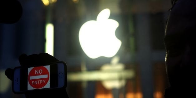 An anti-government protester holds up his iPhone with a sign 'No Entry' during a demonstration near the Apple store on Fifth
