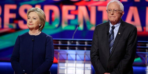 Democratic presidential candidates Hillary Clinton, left, and Sen. Bernie Sanders, I-Vt., stand on stage before a Democratic