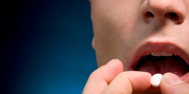 Close-up of a man taking pill