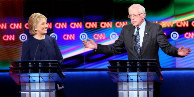 FLINT, MI - MARCH 06: Democratic presidential candidate Senator Bernie Sanders (D-VT) and Democratic presidential candidate Hillary Clinton speak during the CNN Democratic Presidential Primary Debate at the Whiting Auditorium at the Cultural Center Campus on March 6, 2016 in Flint, Michigan. Voters in Michigan will go to the polls March 8 for the state's primary. (Photo by Scott Olson/Getty Images)