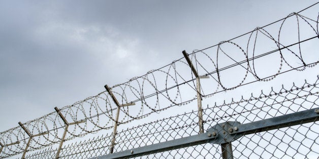 wired fence with barbed wires on blue sky background 