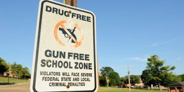 Drug and gun free school zone with violation sign.