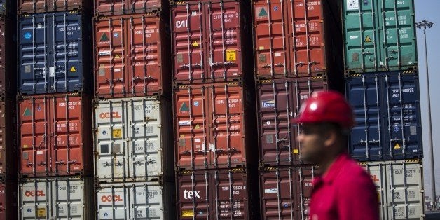An Iranian safety inspector walks past stacked shipping containers at Shahid Rajaee port, some 20 kms west of Gulf port city