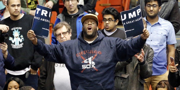 A protester holds up a ripped campaign sign for Republican presidential candidate Donald Trump before a rally on the campus of the University of Illinois-Chicago, Friday, March 11, 2016, in Chicago. (AP Photo/Charles Rex Arbogast)