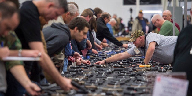 CHANTILLY, VA - OCTOBER 3: People look at handguns as thousands of customers and hundreds of dealers sell, show, and buy guns and other items during The Nation's Gun Show at the Dulles Expo Center which is the first major gun show in the area since the Oregon shooting in Chantilly, VA on Saturday, October 03, 2015. (Photo by Jabin Botsford/The Washington Post via Getty Images)