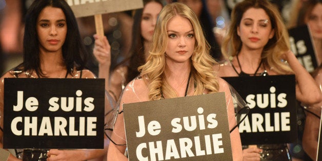 ANTALYA, TURKEY - JANUARY 9: Model Lindsay Ellingson (C) holds a sign reading 'Je suis Charlie' as shedisplays a creation during the 19th Dosso Dossi Fashion Show on January 09, 2015 in Antalya, Turkey. (Photo by Suleyman Elcin/Anadolu Agency/Getty Image)