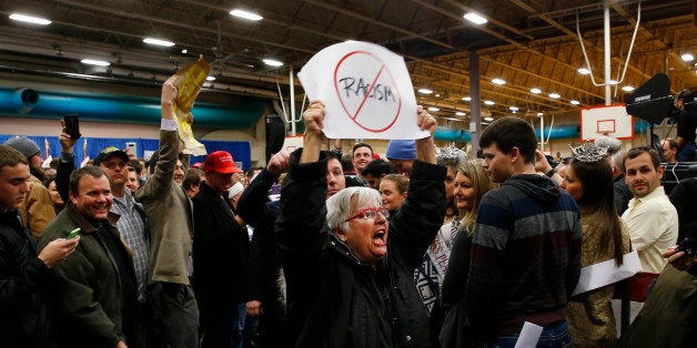 A protester yells as Republican presidential candidate Donald Trump speaks during a campaign event at the University of Iowa