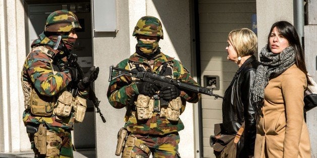 Women speak to soldiers as they block the access to road close to Maalbeek metro station in Brussels on March 22, 2016 after