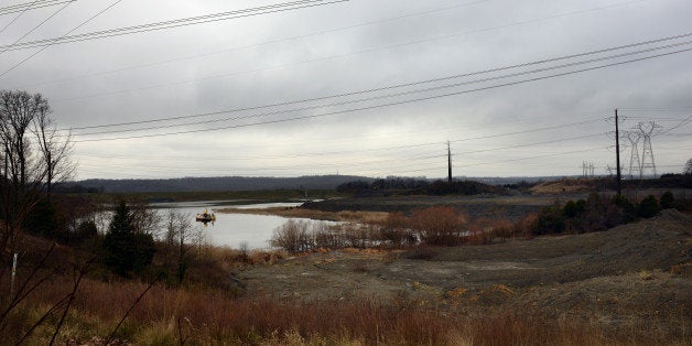 DUMFRIES, VA - JANUARY 7: Environmentalist Dean Naujoks, who joined Potomac Riverkeeper Network in 2015 as the Potomac Riverkeeper, points out the coal ash pond D which he says has been leaking heavy metals into the ground water and contaminated the nearby creeks and rivers for years in Dumfries, VA, January 7, 2016. To the right are piles of coal ash dumped next to coal ash pond D which is filled with roughly 150 million gallon of contaminated water, Naujos says. Naujoks, fellow environmentalists and local officials opposed a Dominion power company proposal to drain about 210 gallons of coal ash-contaminated water of coal ash pond D into Quantico Creek, after the water is treated. A drain connected to one of the ponds has been leaking untreated water into the creek for decades, Naujoks says. Coal Ash is a Hazardous Waste. Coal ash is the toxic remains of coal burning in power plants. It is loaded with cancer causing chemicals and can lead to developmental disorders and reproductive problems. (Photo by Astrid Riecken For The Washington Post via Getty Images)