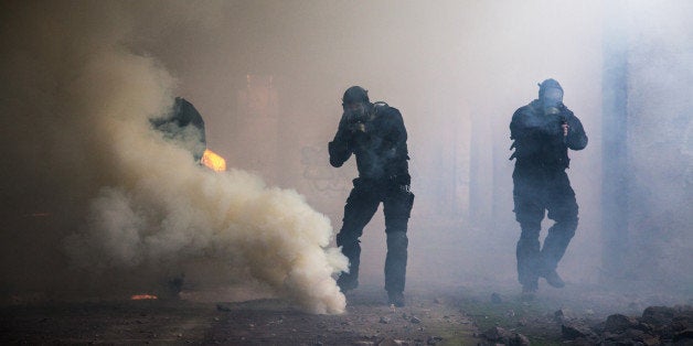 Special forces operator in black uniform in the smoke