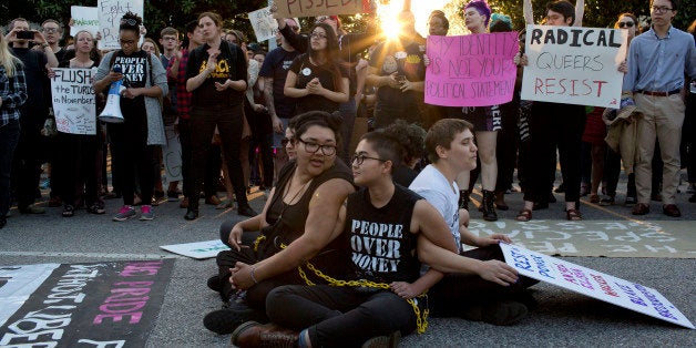 Front from left, demonstrators Jess Jude, Loan Tran and Noah Rubin-Blose, sit chained together in the middle of the street du