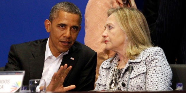 U.S. President Barack Obama and Secretary of State Hillary Clinton talk during the plenary session of the Summit of the Ameri