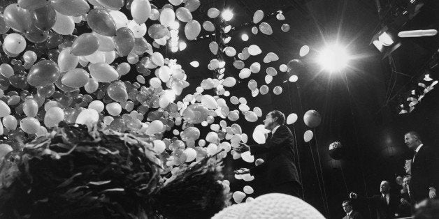 31st October 1968: Republican presidential candidate Richard Nixon (1913-1994) is showered by balloons while standing on sta