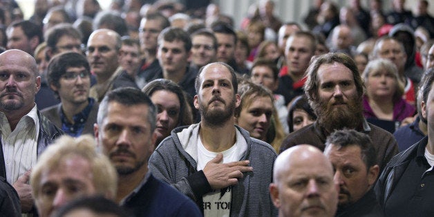 Attendees listen to the U.S. National Anthem at the start of a campaign event for Donald Trump, president and chief executive