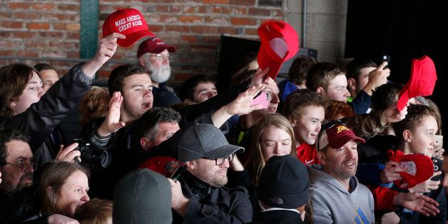 Supporters try to get the attention of Republican presidential candidate Donald Trump after he spoke Monday, April 4, 2016, during a campaign rally in a hangar at the Bong Airport in Superior, Wis. (AP Photo/Jim Mone)