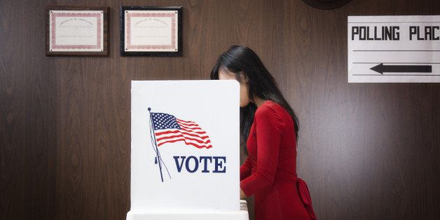 Asian voter voting in polling place