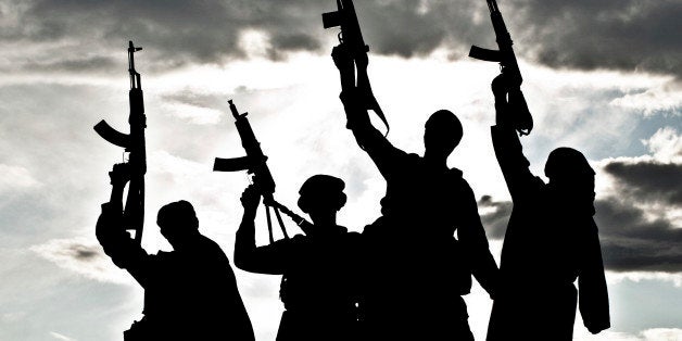 Silhouette of several muslim militants with rifles