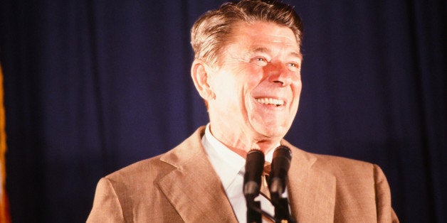 During his presidential campaign, American politician (and future US President) Ronald Reagan (1911 - 2004) smiles from behin