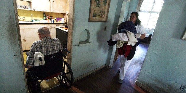 MIAMI - DECEMBER 14: United HomeCare Services home health aide Wendys Cerrato carries bedding to the washing machine as she helps Robert Granville in his home on December 14, 2009 in Miami, Florida. The U.S. Senate continues to debate the need for the Community Living Assistance Services and Supports (CLASS) Act in the health care reform bill, which would provide a government-sponsored basic cash benefit to those needing long-term care services at home, in assisted living, or in a nursing facility. Without the help of United HomeCare Services Robert would be unable to continue to live on his own since he has limited mobility. (Photo by Joe Raedle/Getty Images)