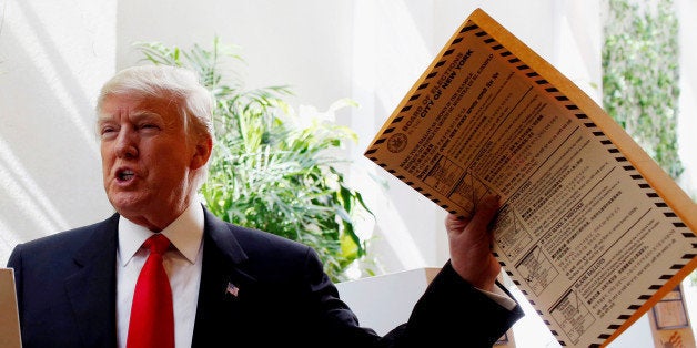 Republican presidential candidate Donald Trump lifts his ballot while voting for the New York primary election in the Manhattan borough of New York City, U.S., April 19, 2016. REUTERS/Andrew Kelly 