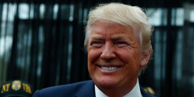 Republican presidential candidate Donald Trump poses for a picture with supporters at the end of a press conference with members of the New York Veteran Police Association in Staten Island, New York on April 17, 2016. / AFP / KENA BETANCUR (Photo credit should read KENA BETANCUR/AFP/Getty Images)