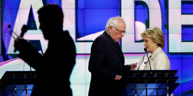 Democratic presidential candidates Sen. Bernie Sanders, I-Vt., left, and Hillary Clinton pass during a break at the CNN Democratic Presidential Primary Debate at the Brooklyn Navy Yard on Thursday, April 14, 2016 in New York. (AP Photo/Seth Wenig)