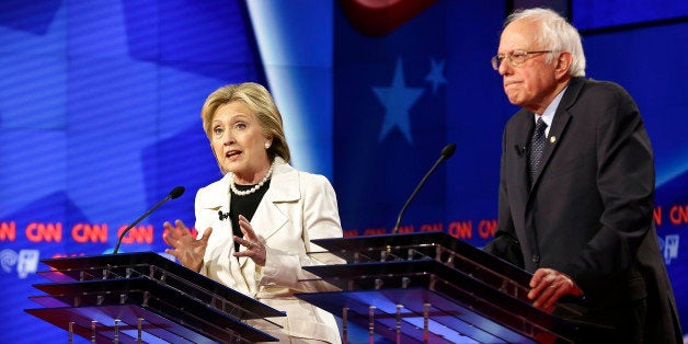 Democratic presidential candidates Sen. Bernie Sanders, I-Vt., right, listens as Hillary Clinton speaks during the CNN Democr
