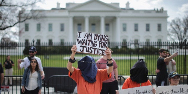 WASHINGTON, DC - MARCH 11: Loyola University Chicago students demonstrating for human dignity are joined by people protesting against the military prison at Guantanamo Bay Naval Base on the north side of the White House March 11, 2016 in Washington, DC. Marking the 14th anniversary of detainees arriving at Guantanamo, the protesters again called on President Barack Obama to close the military prison in Cuba. (Photo by Chip Somodevilla/Getty Images)