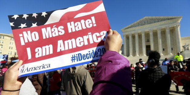 A protester holds her sign up as immigrants and community leaders rally in front of the U.S. Supreme Court to mark the one-year anniversary of President Barack Obama's executive orders on immigration in Washington, November 20, 2015. The Obama administration on Friday asked the U.S. Supreme Court to revive President Barack Obama's executive action to protect millions of illegal immigrants from deportation, saying Republican-led states had no legal basis to challenge it. REUTERS/Kevin Lamarque