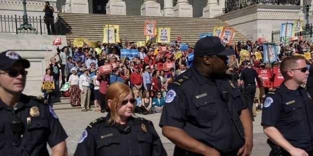 US Capitol Police surround activists during the 'Congress with Conscience' rally on Capitol Hill April 18, 2016 in Washington, DC. / AFP / Brendan Smialowski (Photo credit should read BRENDAN SMIALOWSKI/AFP/Getty Images)