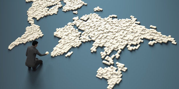 Businessman creating cubes in a world map form.