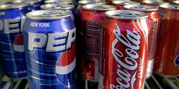 Cans of Pepsi and Coke are shown in a news stand refrigerator display rack in New York Friday, April 22, 2005. (AP Photo/Mark