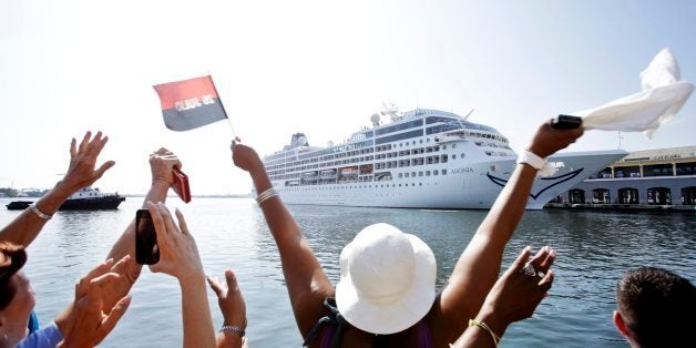 HAVANA, CUBA - MAY 2: A Cuban woman waves with a flag symbolizing the 26-7 Moncada movement of Revolution leader Fidel Castro Cubans as Cubans welcome the arrival of the cruise ship Adonia, the first US cruise ship in nearly forty years to arrive in Cuba, on May 2, 2016, in Havana, Cuba. The Adonia, belonging to the Carnival group, carried some 700 passengers on its sail from Miami to Havana, officially re-establishing the US cruise business in Cuba.(Photo by Sven Creutzmann/Mambo photo/Getty Images)