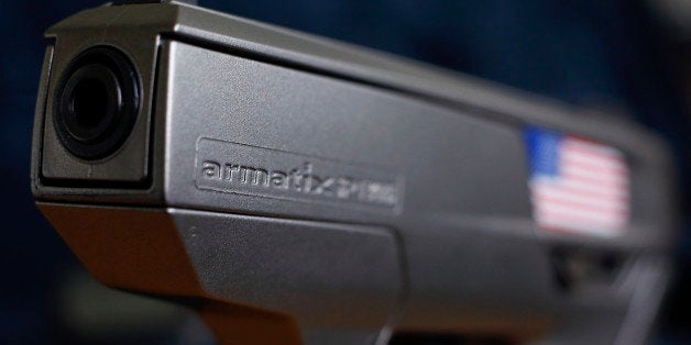 A smart gun by Armatix is pictured at the Armatix headquarters in Munich May 14, 2014. The gun is implanted with an electronic chip that allows it to be fired only if the shooter is wearing a watch that communicates with it through a radio signal. If the gun is moved more than 10 inches (25 cm) from the watch, it will not fire. A Maryland gun shop owner has dropped his plan to be the first in the United States to sell the so-called "smart gun" after a backlash that included death threats. REUTERS/Michael Dalder (GERMANY - Tags: CRIME LAW POLITICS SCIENCE TECHNOLOGY BUSINESS)