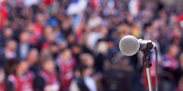 Microphone in focus against unrecognizable crowd