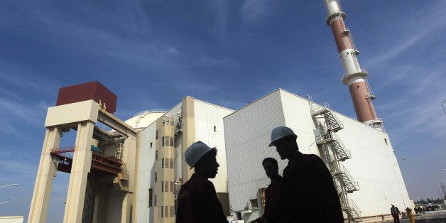 Iranian workers stand in front of the Bushehr nuclear power plant, about 1,200 km (746 miles) south of Tehran October 26, 2010. Iran has begun loading fuel into the core of its first nuclear power plant on Tuesday, one of the last steps to realising its stated goal of becoming a peaceful nuclear power, state-run Press TV reported on Tuesday. REUTERS/Mehr News Agency/Majid Asgaripour (IRAN - Tags: POLITICS ENERGY IMAGES OF THE DAY)