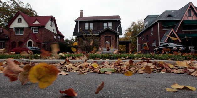 Fall leaves blow past an empty home (C) seen in a well kept neighborhood where the house is listed on the auction block during the Wayne County tax foreclosures auction of almost 9,000 properties in Detroit, Michigan, October 22, 2009. The tax foreclosure auction stood as one of the most ambitious one-stop attempts to sell of urban property since the real-estate market collapse. Picture taken October 22, 2009. REUTERS/Rebecca Cook (UNITED STATES BUSINESS)